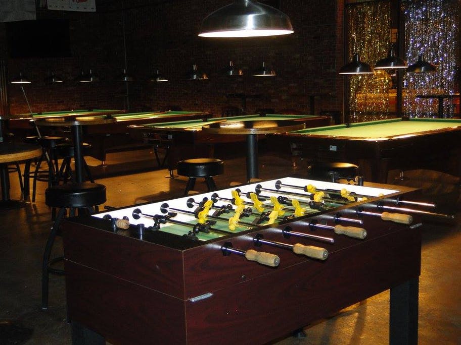 table hockey and pool tables with barstools