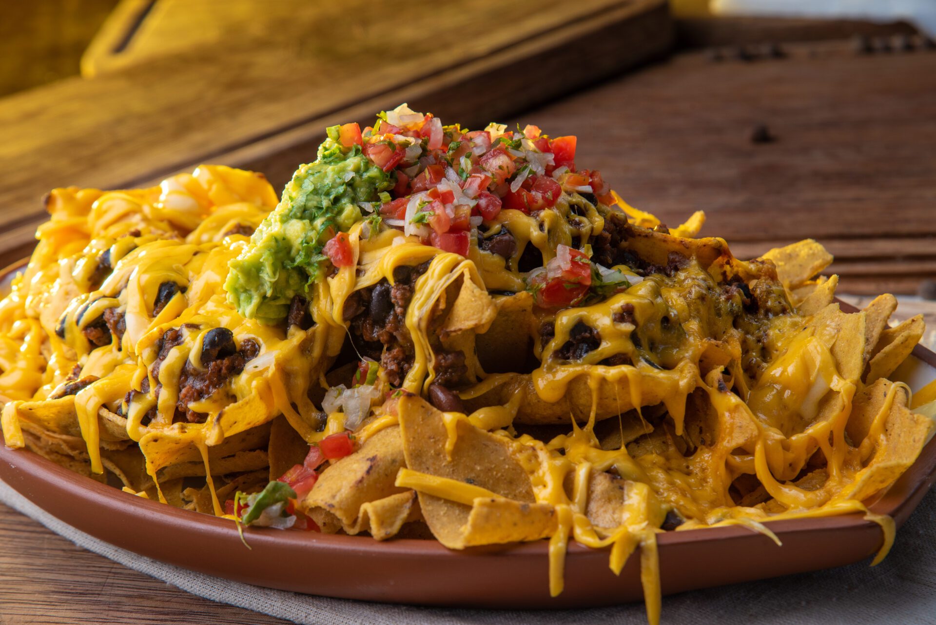 large platter of nachos with vegetables and meat