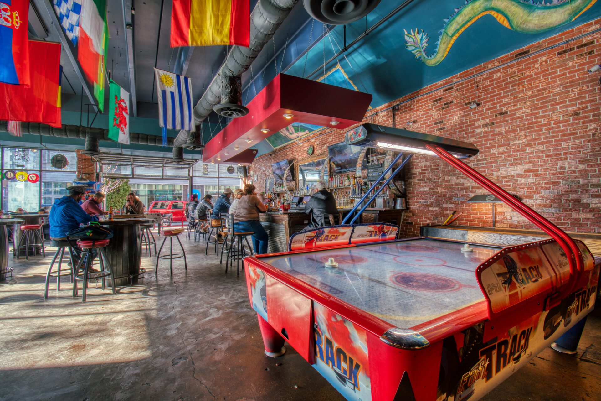 air hockey table with people in barstools and tables